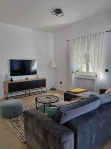 a living room with a couch and a tv at Apartman Sorelle in Kali