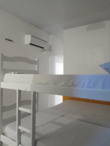 Casa da India في Cairu: سرير بطابقين في غرفة بيضاء مع سلم