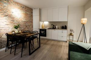 cocina con mesa de comedor y pared de ladrillo en Apartament z Tarasem, en Toruń
