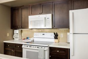 uma cozinha com electrodomésticos brancos e armários de madeira em Horseshoe Valley Suites - The Glade em Shanty Bay
