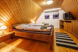 a bed in a room with a wooden ceiling at Chaloupka u Káji in Vítkovice