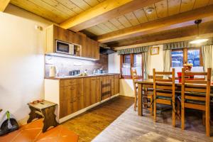 a kitchen and dining room with a table and chairs at Chaloupka u Káji in Vítkovice