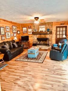 a living room with leather furniture and a fireplace at Robin's Roost in Sevierville