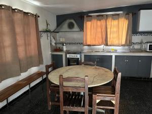 eine Küche mit einem Tisch und Stühlen sowie eine Küche mit einem Herd in der Unterkunft María Chusena alojamiento 1 in Fray Bentos