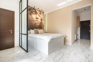 a bedroom with a bed with marble floors and a mirror at Victoriei112 - UrbanNest Bucharest in Bucharest