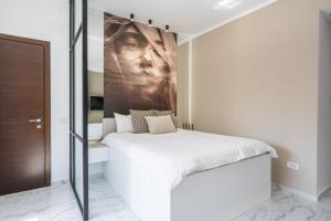 a bedroom with a bed with a painting on the wall at Victoriei112 - UrbanNest Bucharest in Bucharest