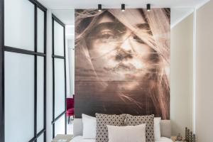a bedroom with a large mural of a woman at Victoriei112 - UrbanNest Bucharest in Bucharest
