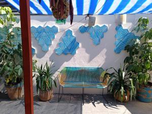 una pared con sombrillas azules y un banco en ella en Monkey Safari Hostel en Querétaro