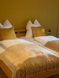 two beds with white blankets and pillows in a room at Gästehaus Reichmann in Beverungen