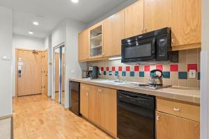 a kitchen with wooden cabinets and a microwave at Studio #247 in Olympic Valley