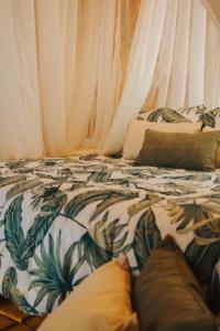 a bed with white curtains and pillows on it at Hotel Campestre Villa Martha in Turbaco