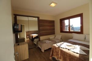 um quarto de hotel com uma cama e uma televisão em Valle Dell Acqua em Gramado