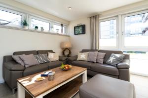 ein Wohnzimmer mit einem Sofa und einem Tisch in der Unterkunft Sölring Lek Westerland in Westerland