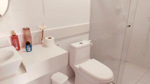 Baño blanco con aseo y lavamanos en Casa Ventos Guaibim en Guaibim