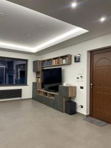 a living room with a flat screen tv and a door at Sciara Casa Vacanze in Pedara