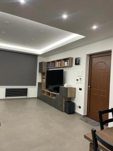 a living room with a flat screen tv and a door at Sciara Casa Vacanze in Pedara