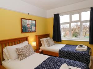 a hotel room with two beds and a window at Sailors Rest, Southwold in Southwold