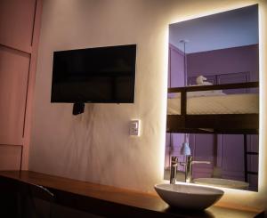 łazienka z telewizorem, umywalką i lustrem w obiekcie La Casona w mieście Santa Cruz de la Sierra