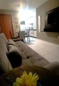 uma sala de estar com um sofá e uma sala de estar com uma cozinha em Apartamento Beira Rio no Condomínio Brisas do Lago em Paulo Afonso