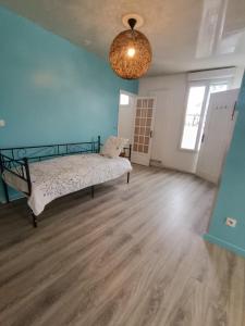 um quarto com uma cama e uma parede azul clara em sci ecs APPART em Ablon-sur-Seine