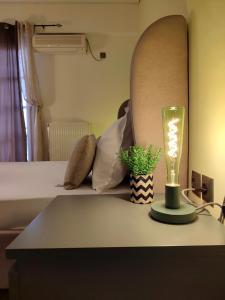 アテネにあるElia Apartmentsのベッドルーム1室(テーブルの上にランプ付きのベッド1台付)
