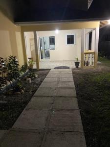 a walkway in front of a house at night at 1 Bed Cottage in Gated Community in Banks