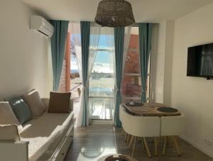 - un salon avec un canapé et une table dans l'établissement CAP ESTEREL, T2 VUE MER 4 couchages adapté PMR, à Saint-Raphaël