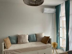 - un canapé dans une pièce avec fenêtre dans l'établissement CAP ESTEREL, T2 VUE MER 4 couchages adapté PMR, à Saint-Raphaël