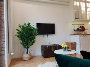 sala de estar con mesa y TV en la pared en FRONTEX CityCenter Galati - disscount on Google!, en Galaţi