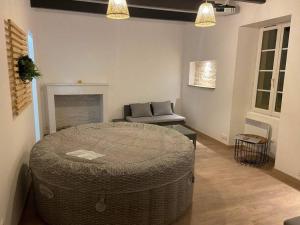uma sala de estar com um grande repousa-pés de vime em frente a uma lareira em Maison en pierre à 15 min de LA ROCHELLE avec SPA em Andilly-les-Marais