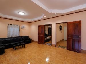 a living room with a black couch and a mirror at Boonsong Guest House in Khao Tao