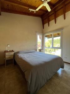 um quarto com uma cama grande e uma janela em Balcones de Montaña em Villa La Angostura