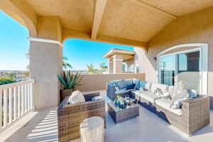 a patio with a couch and chairs on a balcony at Bay Park Villa in San Diego