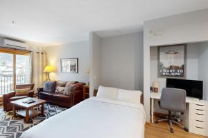 um quarto de hotel com uma cama e uma sala de estar em Snow Flower 101 em Steamboat Springs