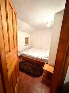 a small bedroom with a bed and a open door at Apartmani Ivan in Kupres