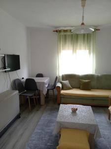 uma sala de estar com um sofá e uma mesa em Apartman Mira&Ahmet em Stolac