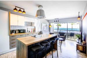 a kitchen with a large island with bar chairs at Flat design with SEA view promenade des anglais in Nice