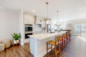 a kitchen with white cabinets and a bar with stools at Sea Oaks Village 5 in Berlin