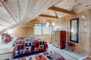 a log cabin bedroom with a bed and a dresser at Wassookeag Getaway in Dexter