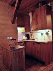 a kitchen with wooden cabinets and a counter top at Très bel appartement au coeur du Parc naturel du Queyras - Aiguilles in Aiguilles