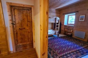 a room with a wooden door and a bed in a cabin at Très bel appartement au coeur du Parc naturel du Queyras - Aiguilles in Aiguilles