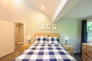 ein Schlafzimmer mit einem Bett mit einer blau-weißen karierten Decke in der Unterkunft SKI Bike, Hike & Golf Townhouse w/ Hot tub in Ellicottville