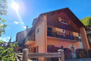 a building with a wooden fence in front of it at Appartement de charme, vue sur les montagnes. in Aiguilles