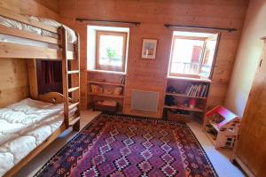 a bedroom with bunk beds and a rug at Appartement de charme, vue sur les montagnes. in Aiguilles