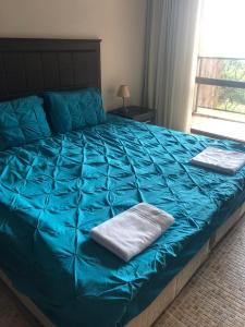 uma grande cama azul com uma toalha em 2 Bed, Royal Beach Barcelo Hotel em Sunny Beach