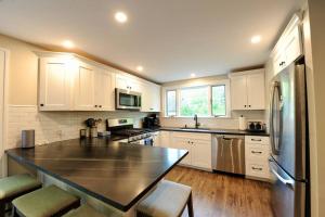 eine Küche mit weißen Schränken und einer schwarzen Arbeitsplatte in der Unterkunft SKI Bike, Hike & Golf Townhouse w/ Hot tub in Ellicottville