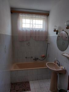 a bathroom with a tub and a sink at Holiday House Retro in Szántód