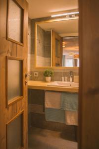 ein Bad mit einem Waschbecken und einem Spiegel in der Unterkunft Garni Stefani in Vent