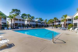 une piscine avec des chaises et des palmiers dans l'établissement Barefoot Cottages #B48, à Highland View