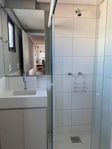 a bathroom with a glass shower and a sink at Super compacto aconchegante. in Porto Alegre